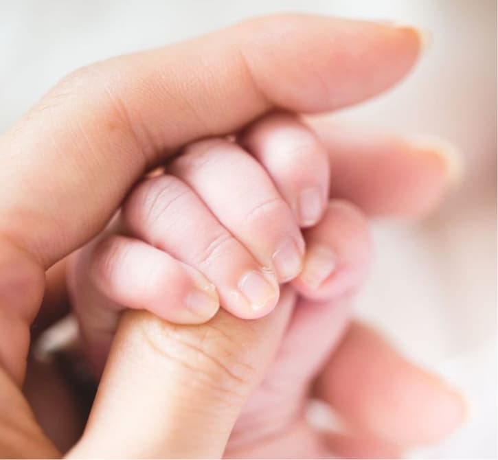 Image of a mother holding babe's hand